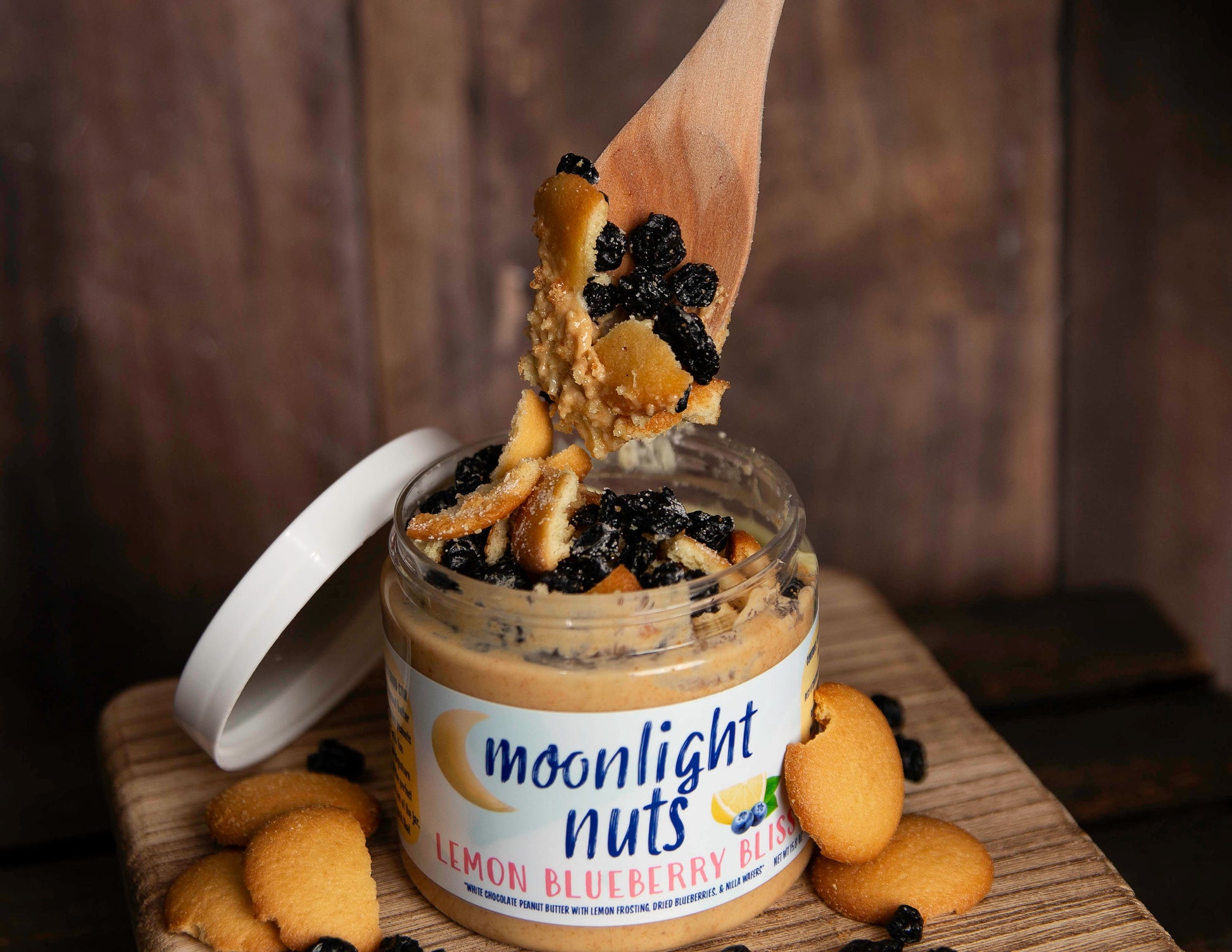 Spoonful of Moonlight Nuts Lemon Blueberry Bliss peanut butter showing all of the toppings: nilla wafers, dried blueberries, lemon frosting  