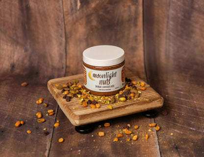 Jar of Dubai chocolate moonlight nuts peanut butter with crushed pistachios scattered