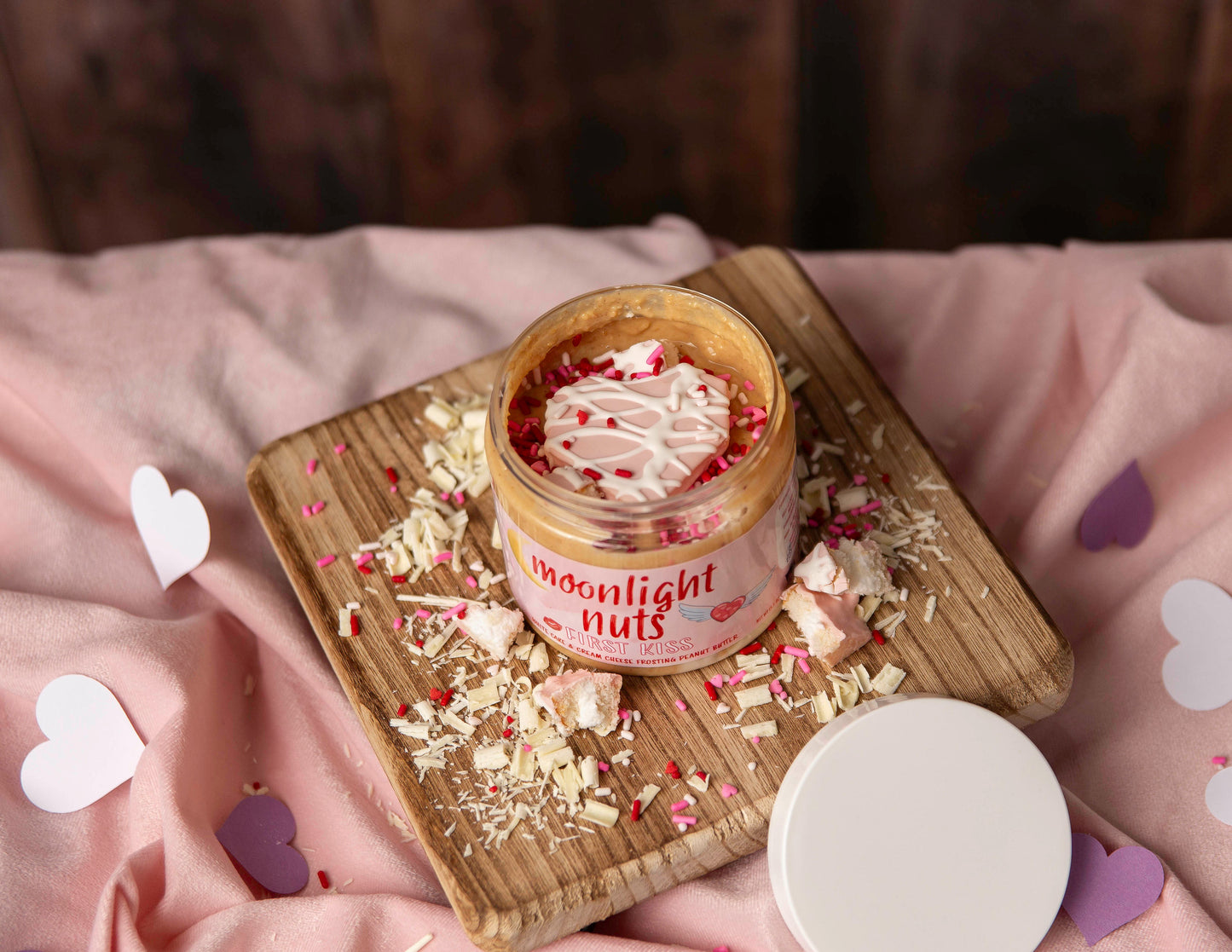 Overhead view of moonlight nuts peanut butter featuring white chocolate peanut butter and white heart shaped cake.