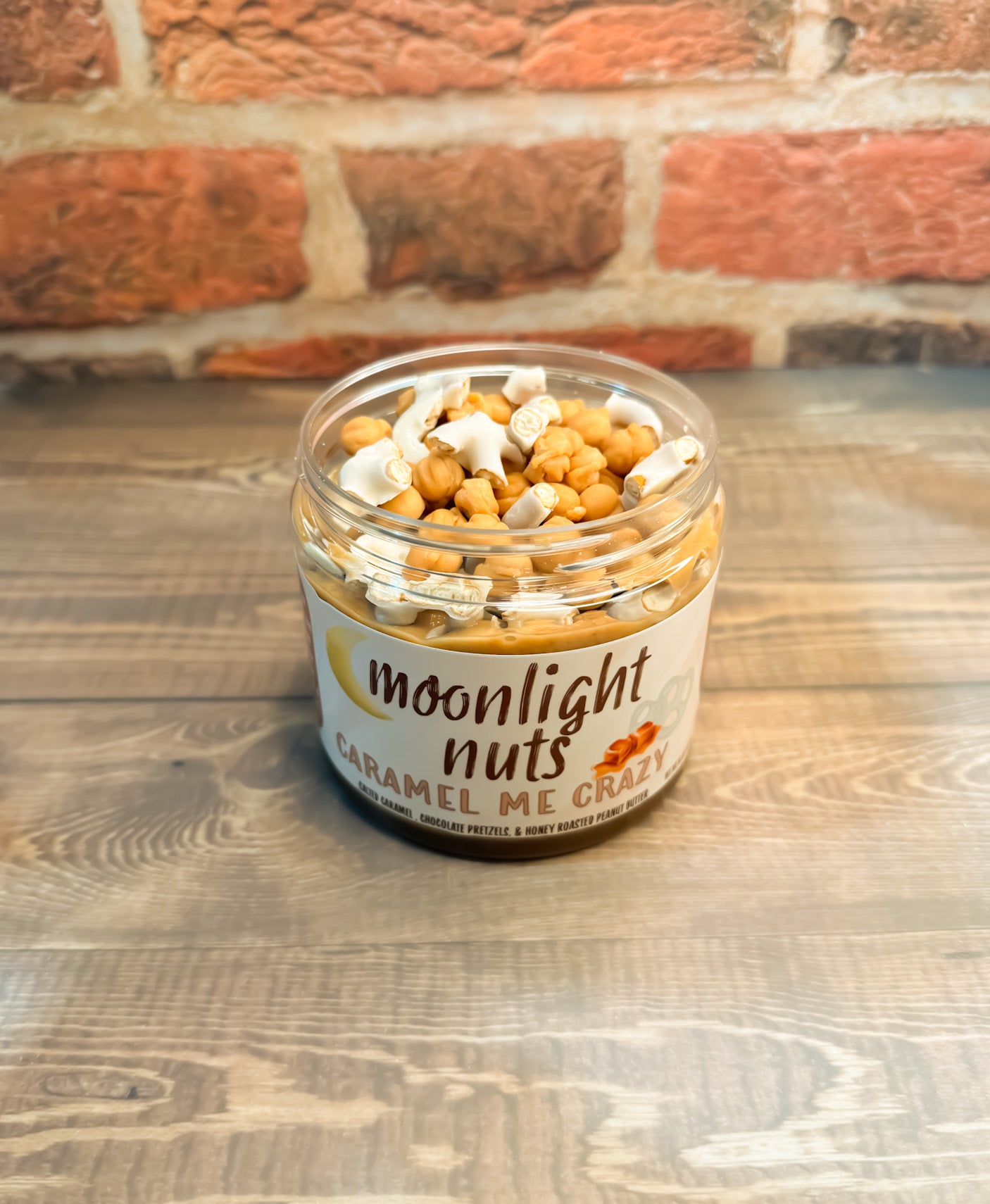 Jar of moonlight nuts “caramel me crazy” peanut butter showing some of the toppings