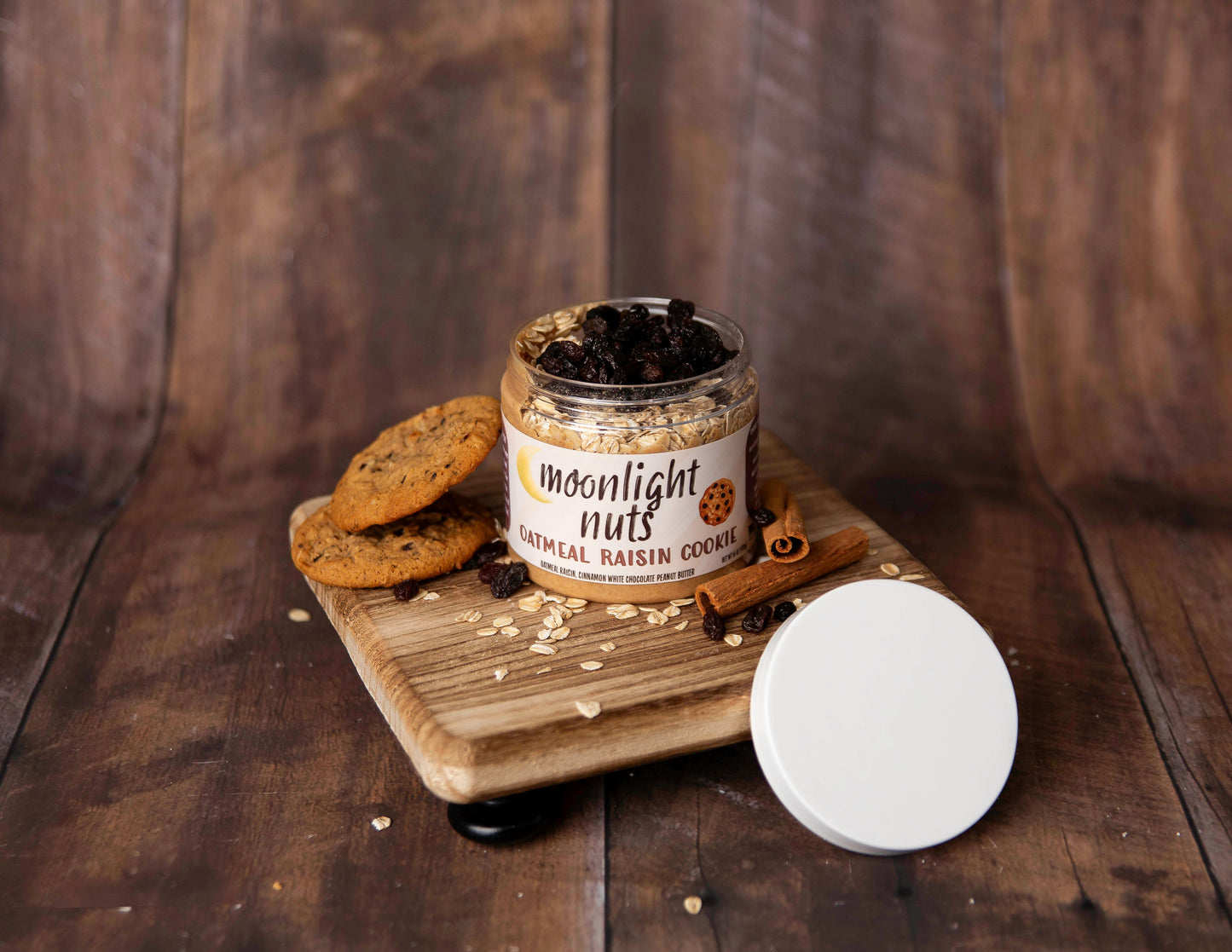 Open jar of Moonlight Nuts Oatmeal Raisin Cookie peanut butter showing oats and raisins in the cinnamon white chocolate peanut butter