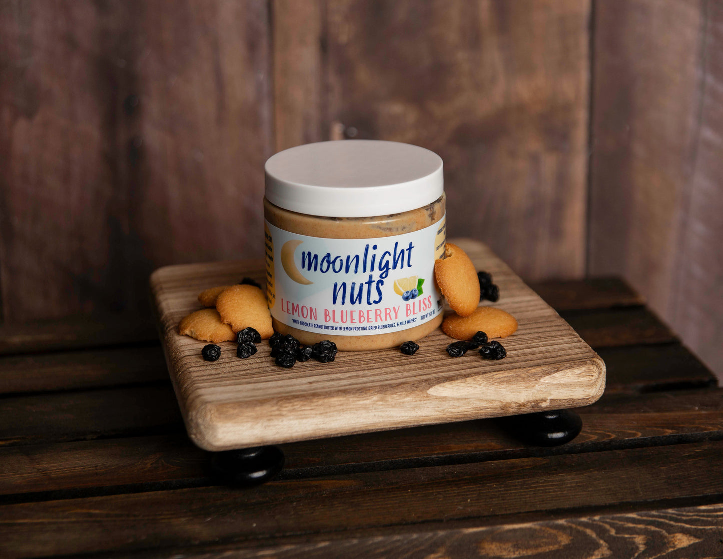 Jar of Moonlight Nuts Lemon Blueberry Bliss peanut butter with some of the toppings laid around it 