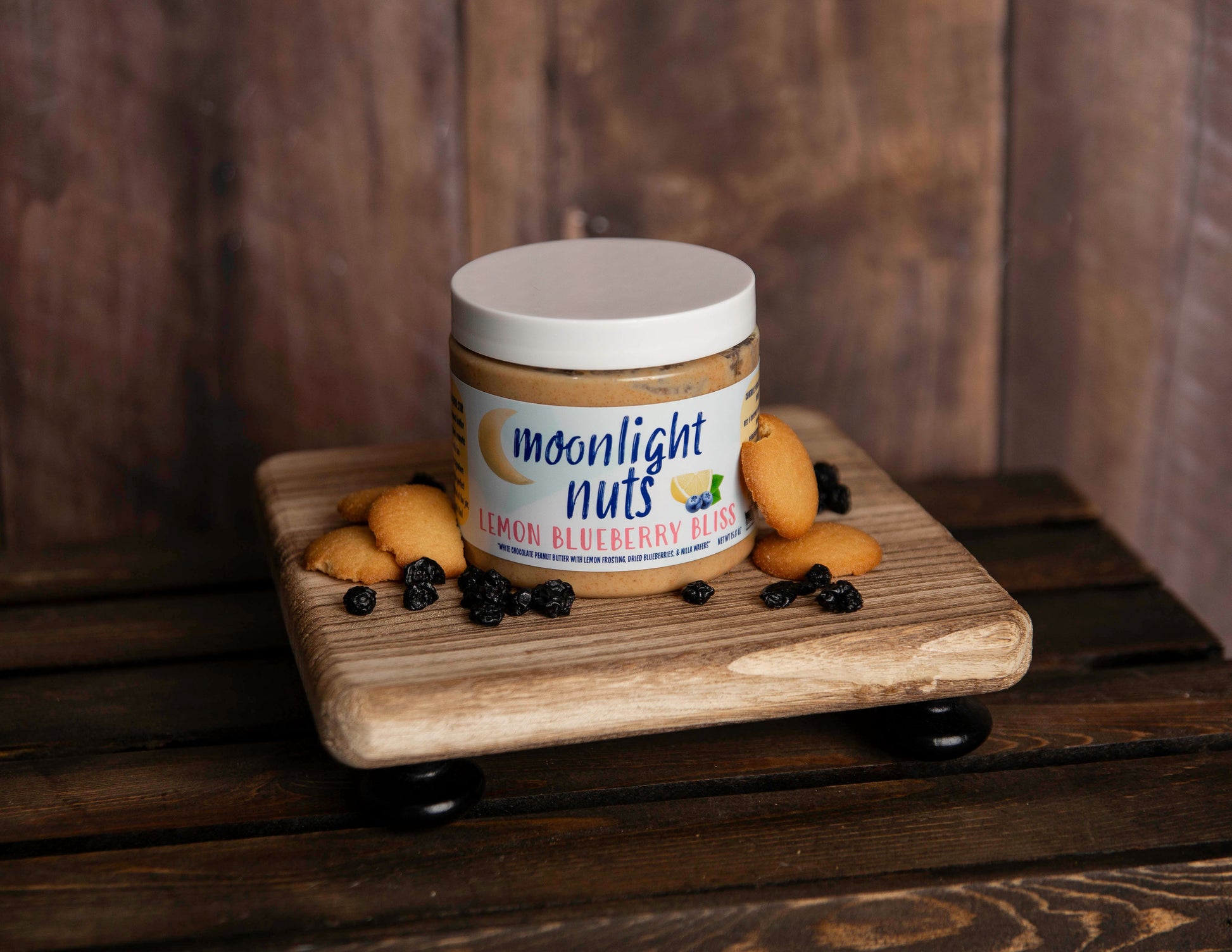 Jar of Moonlight Nuts Lemon Blueberry Bliss peanut butter with some of the toppings laid around it 