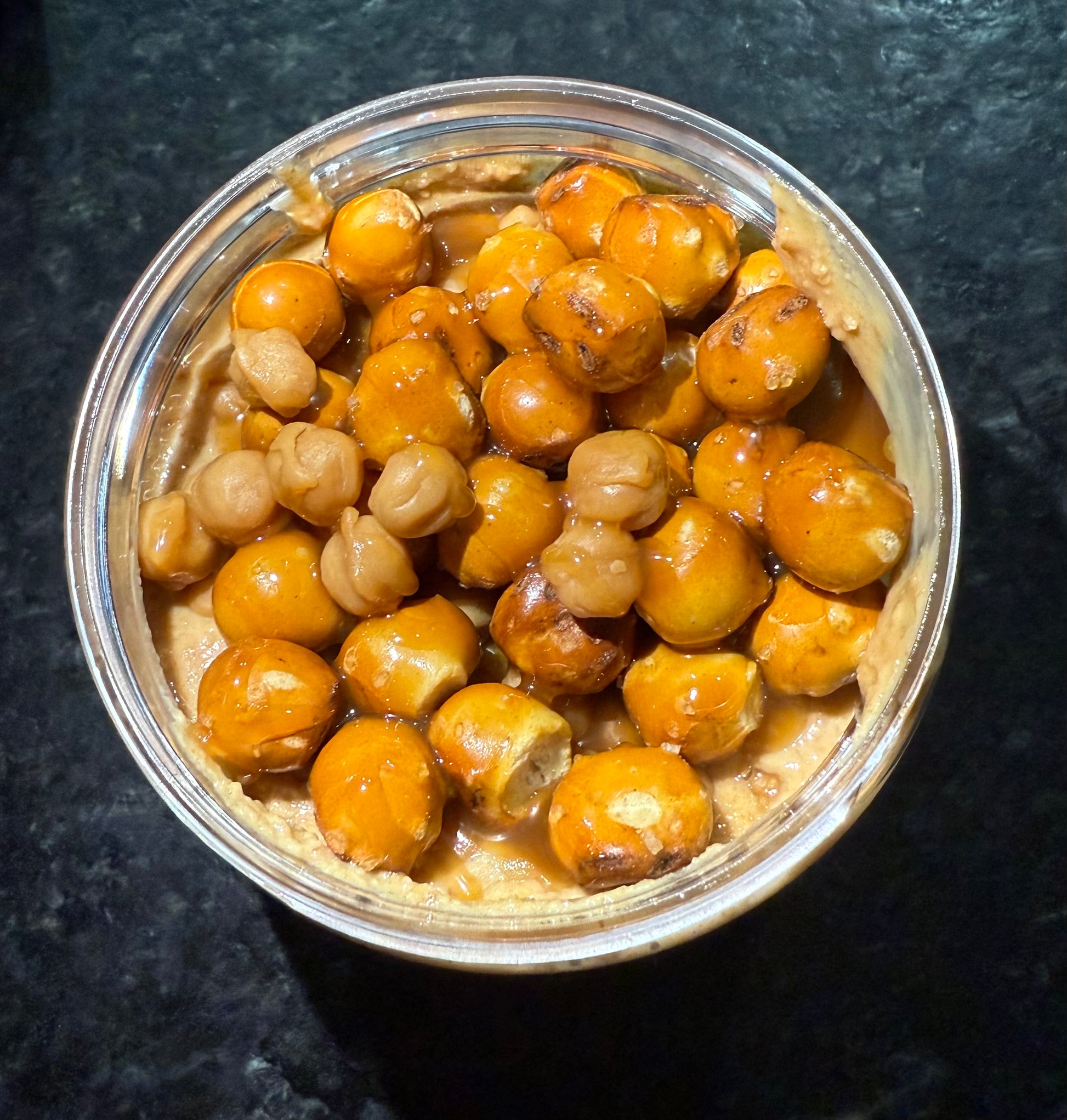 Jar of peanut butter with caramel bits and pretzel rounds