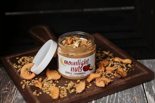 Jar of Apple Crumble peanut butter with apple pieces and granola topping