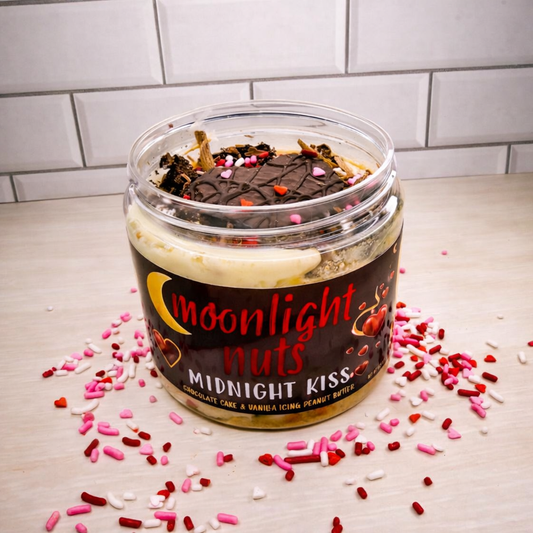 Jar of 'Moonlight Nuts Midnight Kiss' dessert peanut butter with sprinkles on a light surface.